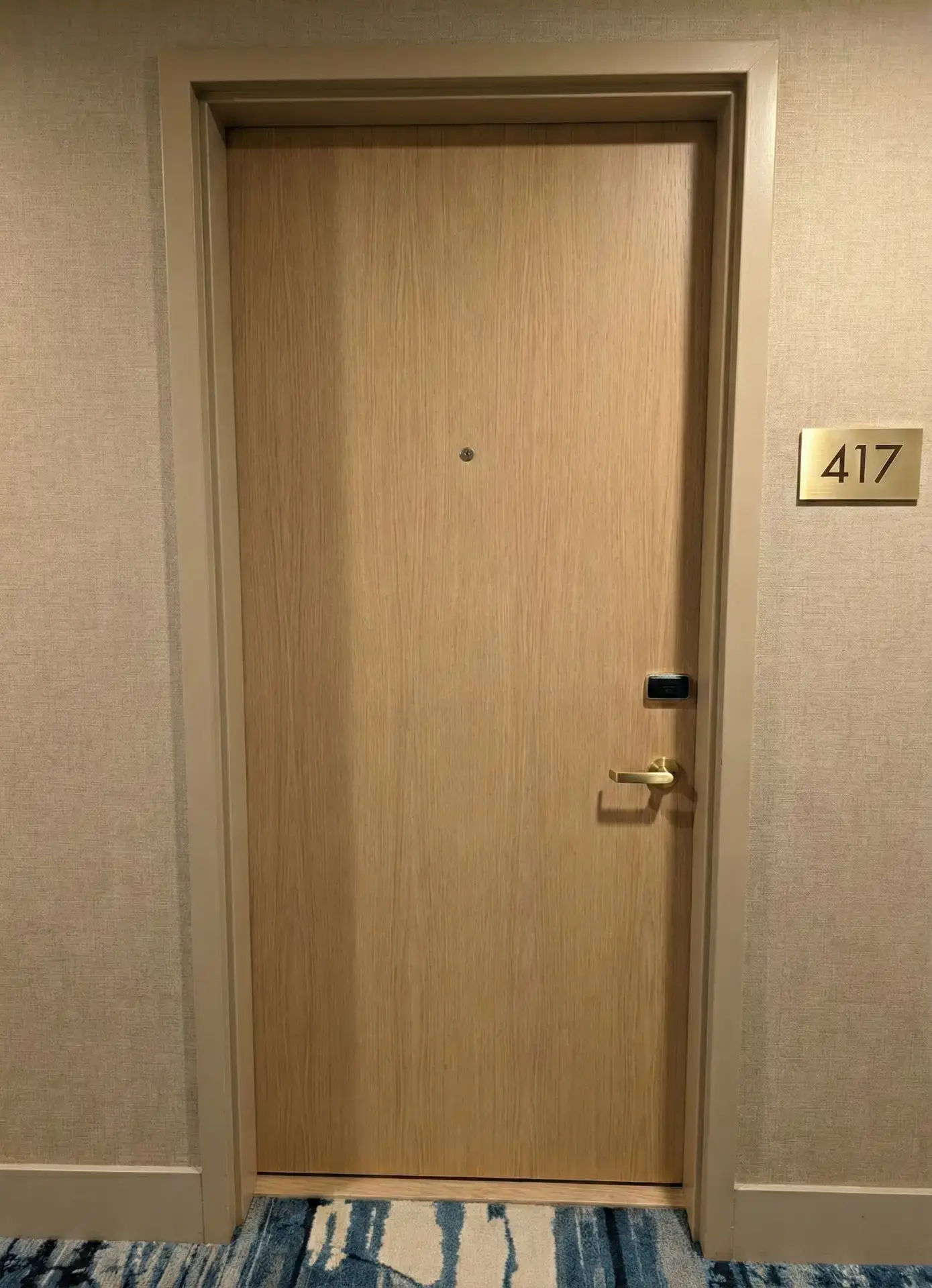 Hotel door after blond oak architectural vinyl wrap installation